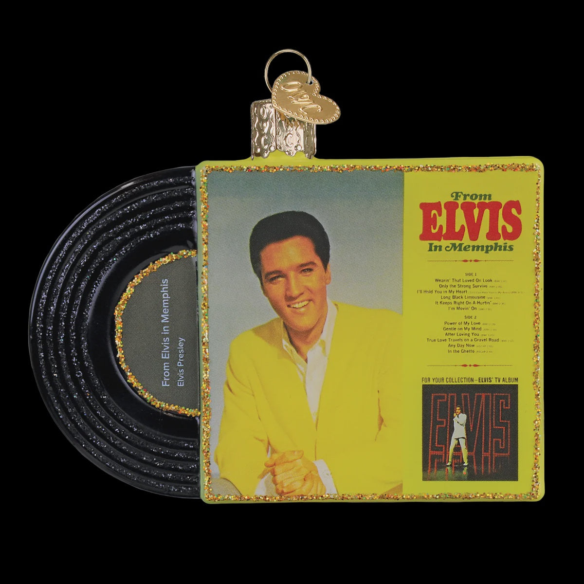 A Christmas ornament shaped like an Elvis Presley vinyl record, featuring a black record sleeve with gold glitter trim and a front cover photo of Elvis in a yellow suit against a black background.