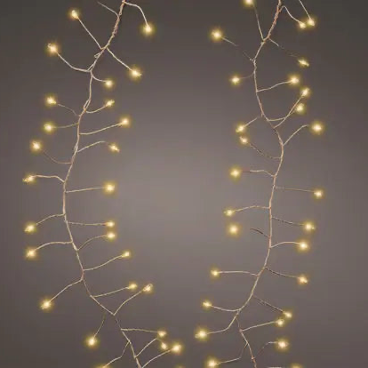 Warm white LED fairy string lights on a thin branch-like wire frame, arranged in two vertical strands against a dark gray background.