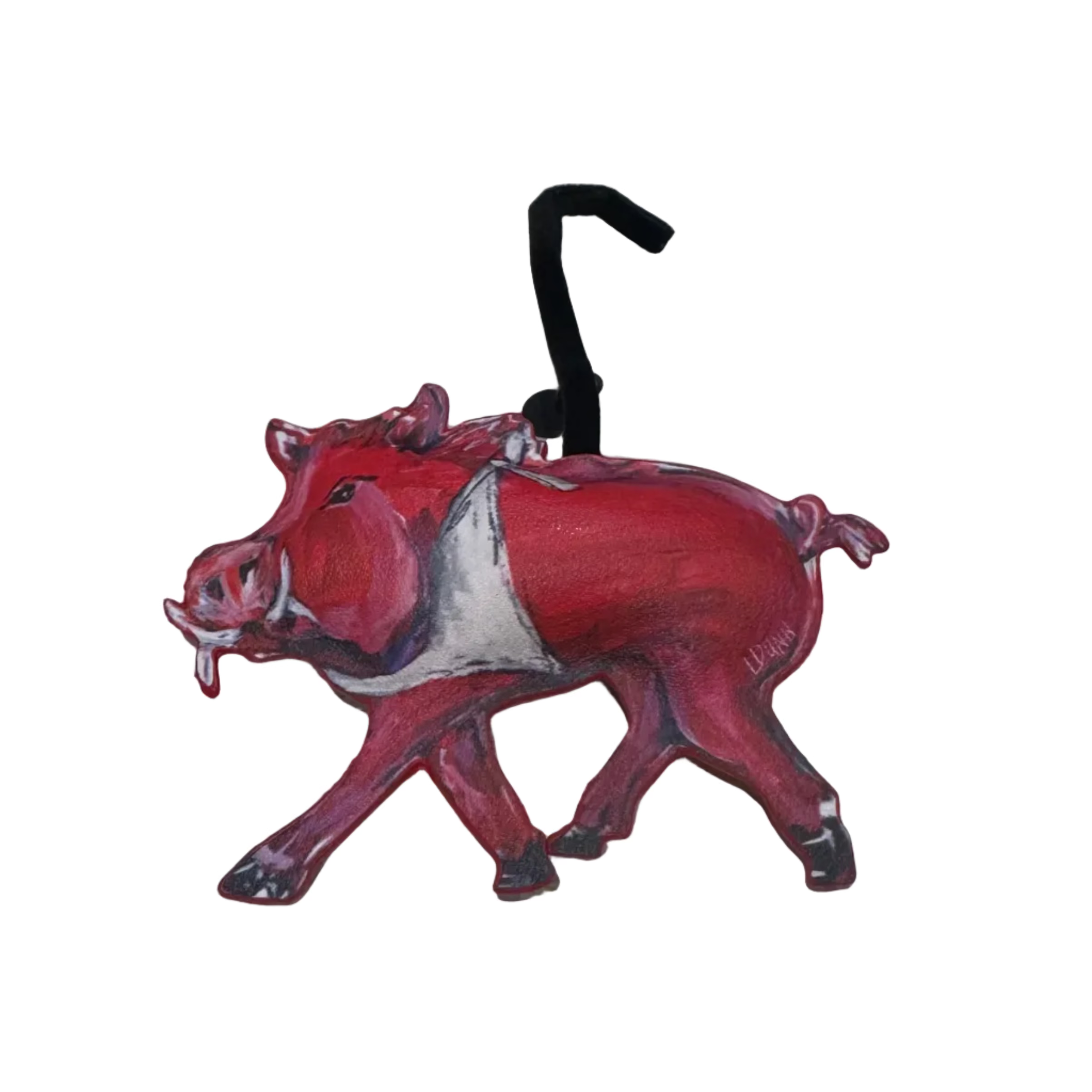 A red and white painted pig-shaped luggage tag with a black plastic hook, resting on a light gray textured surface.