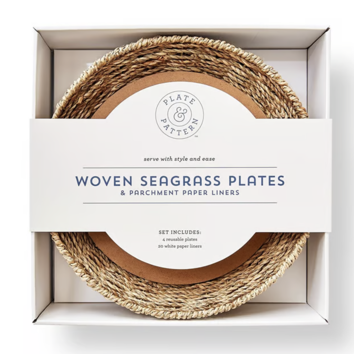 A set of woven seagrass plates and parchment paper liners in a white gift box. The circular white label in the center reads 'Plate Pattern' and 'Woven Seagrass Plates & Parchment Paper Liners'.