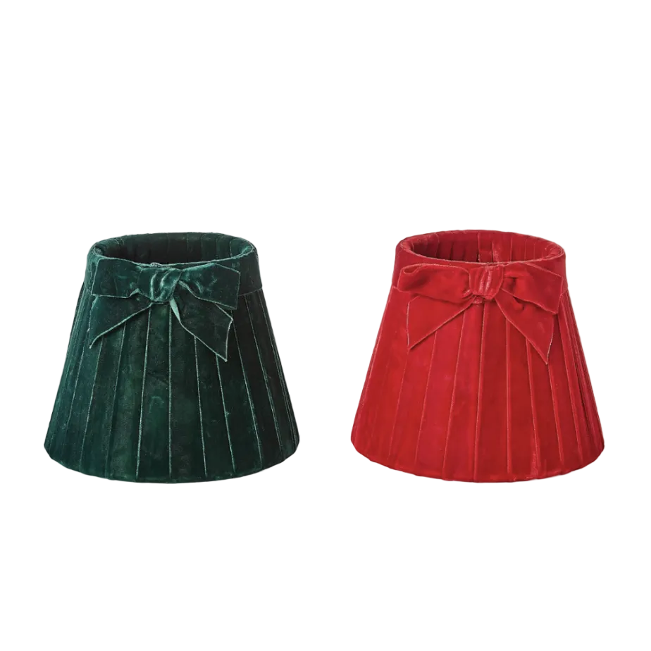 Two pleated velvet lampshades, one dark green and one red, both with a bow at the top, shown on a white background.