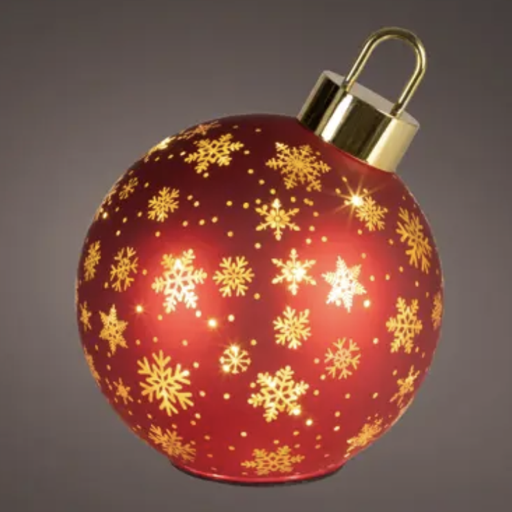 A red Christmas ornament ball with gold snowflakes and gold hanging cap, shown on a dark gray gradient background.