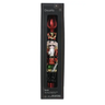 A decorative nutcracker-shaped glass candle in its original black retail packaging, featuring a red top and a detailed nutcracker figure with gold, red, white, and green accents.