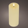 A single lit faux pillar candle in a warm cream or ivory tone, shown upright against a dark gray gradient background.