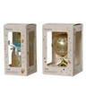 Two Decoris glass Christmas ornament packages shown side by side on a white background. The left package contains a gold ornament with a blue glittery top and a silver bow.