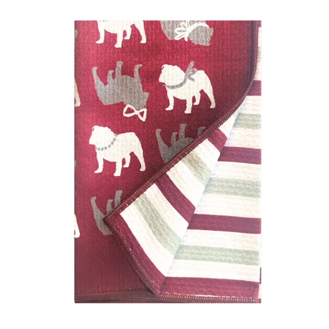 A folded blanket or throw featuring a dark red front with a pattern of bulldog silhouettes in white and gray, and a striped reverse side in burgundy, white, and pale green.