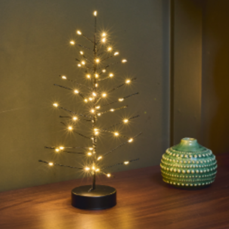 A small black metal tree light with warm white LED lights on a wooden shelf, styled next to a green textured ceramic pot.