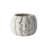 White ceramic pumpkin with jack-o'-lantern face on a white background